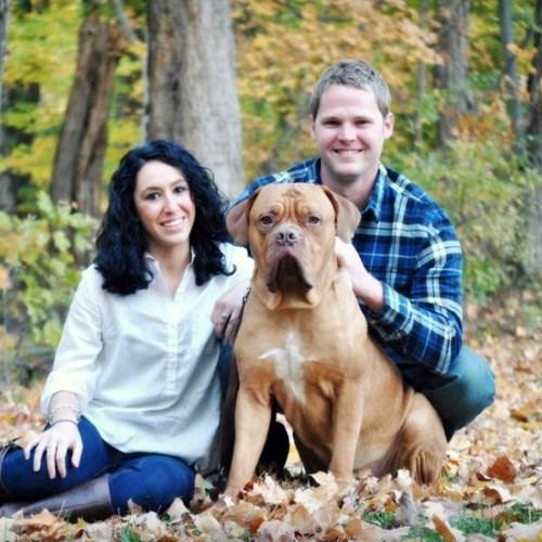 Samantha Taffer smiling with her husband Cody Hanley and grasp a dog
