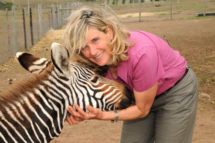 Suzi Egli smiling with zebra