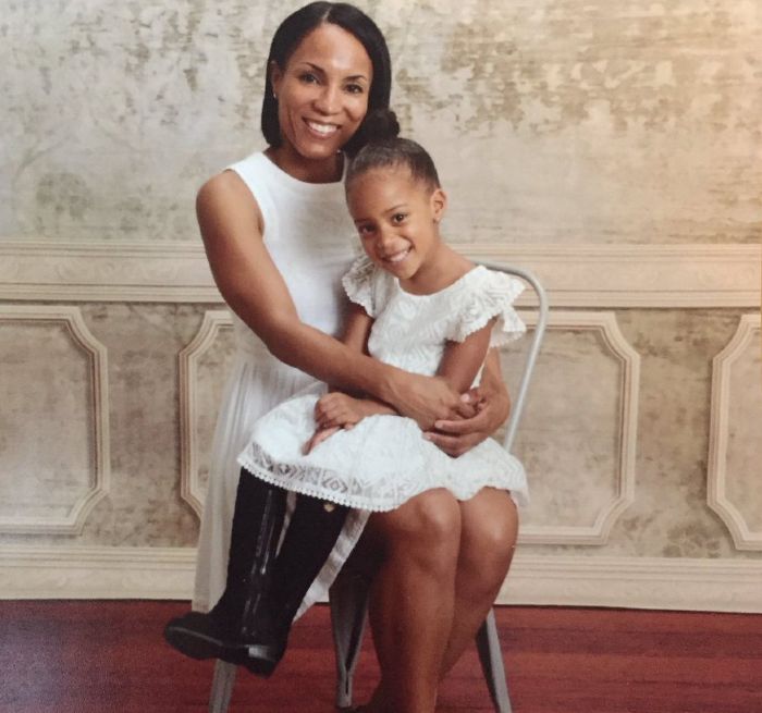 Tamika Fuller smiling in white outfit with her daughter