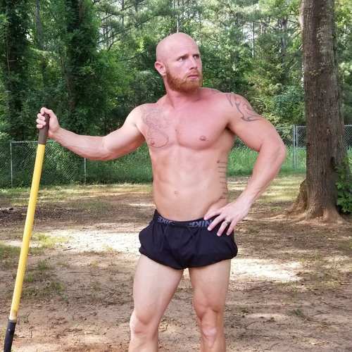 Shirtless Ginger Billy posing with a stick